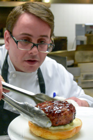 Michael Dussault plating a burger at the International in Bolton, MA