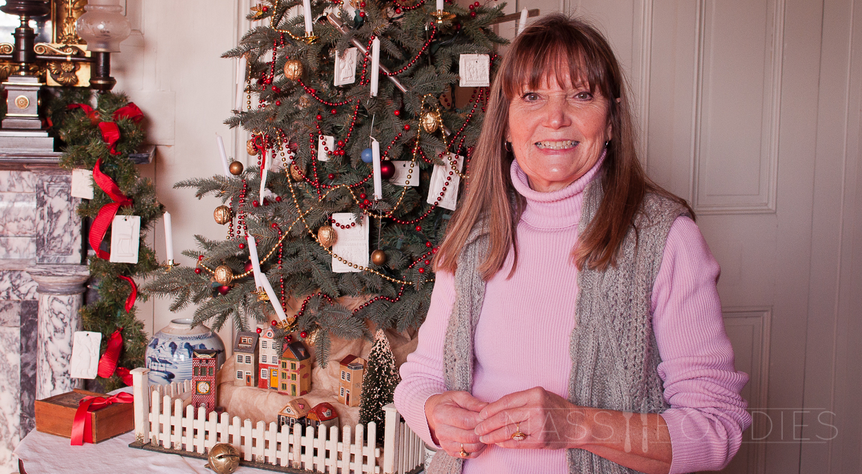 Judi Vaillancourt, from Vaillancourt Folk Art in Sutton, posing with decorations done at the Salisbury Mansion in Worcester, MA