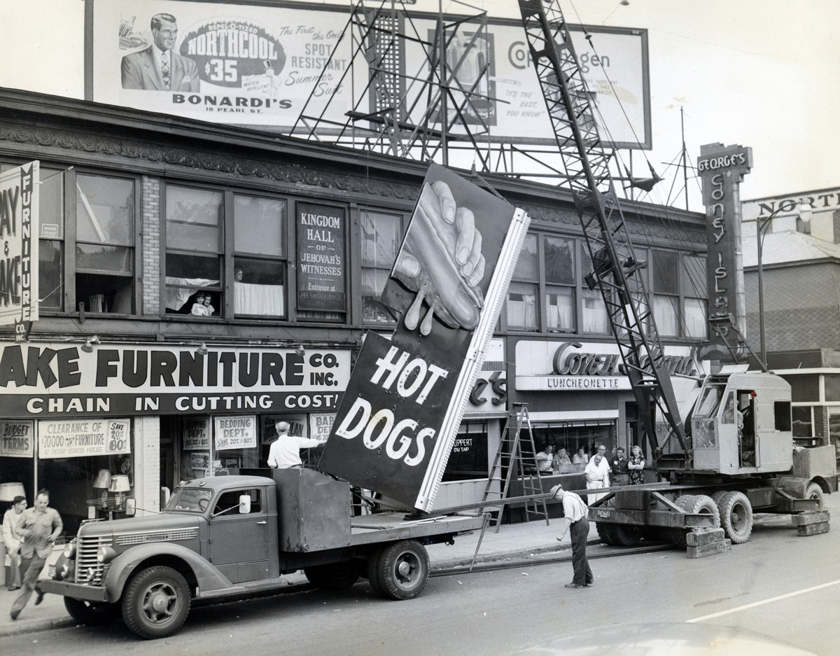 Installing the famous sign at George's Coney Island in Worcester, MA. Photo from the collection at Worcester Historical Museum.