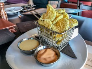 Crispy Fried Pickle Chips from 110 Grill in Worcester, MA (CRISPY DILL PICKLE CHIPS, SERVED WITH HONEY MUSTARD AND SRIRACHA AIOLI DIPPING SAUCES.)